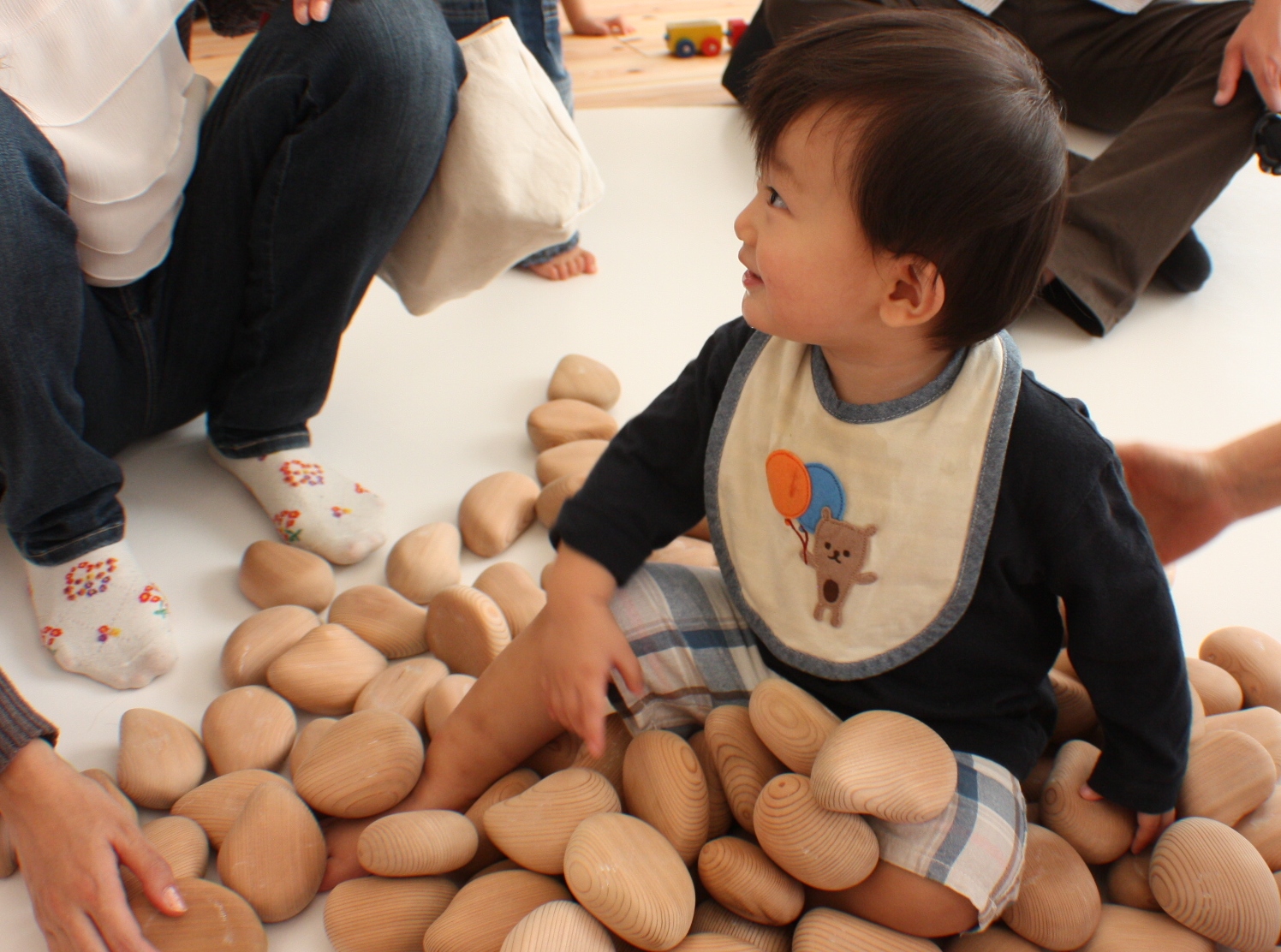 たくさんの木のおもちゃで遊ぶ赤ちゃん